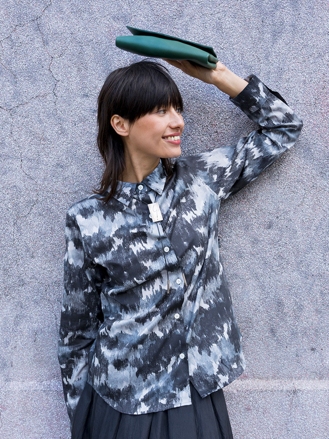 Textures of the city  The 'Andy' shirt features a brushed print that reinterprets camouflage with an urban twist, paired with the 'Tina' pouch in cowhide leather.
